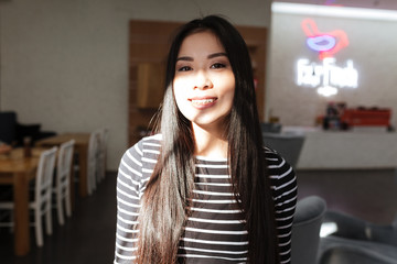 Pleased Asian woman in cafeteria