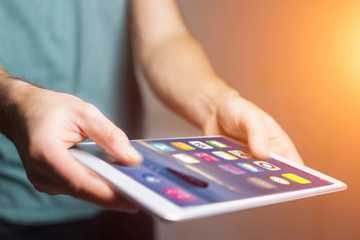 Hand holding black tablet with operating system screen