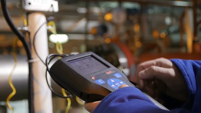 Worker Holds in Hand New Remote Controller in Workshop
