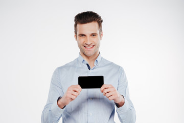 Fototapeta na wymiar Smiling man in shirt showing blank smartphone screen