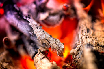 Ignite the fire. Warming up the cold winter nights. A macro shot of firewood, white dust and hot, glowing coal. Burning branches and wood. Flames in the fireplace, cozy home, warmth, love, romantic