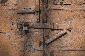 Old antique door with chipped paint and rusted lock. Macro shot.