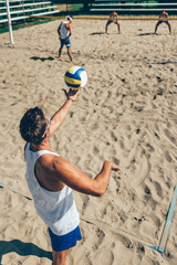 Beach volleyball Player about to serve the ball