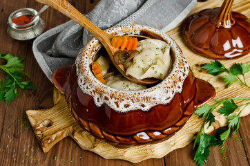 Dumplings in a pot on a wooden table