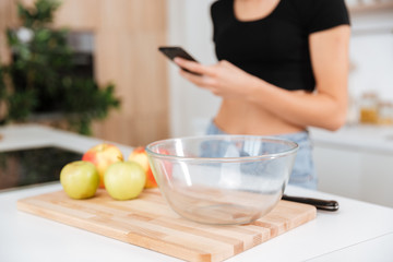 Fototapeta na wymiar Cropped image of woman in kitchen using phone