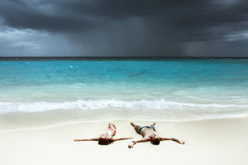 Fototapeta na wymiar Happy couple relaxing on white beach