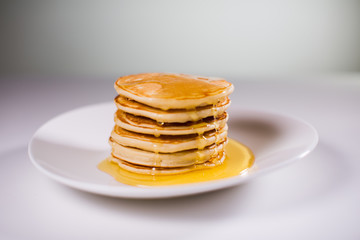 Fototapeta na wymiar Stack of Small pancakes in syrup