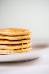 Stack of Small pancakes in syrup