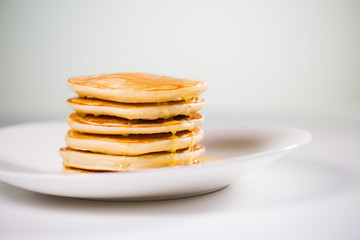 Stack of Small pancakes in syrup