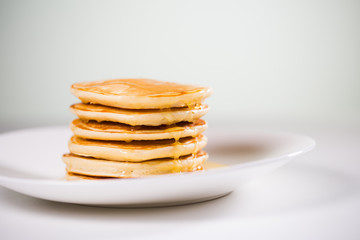 Stack of Small pancakes in syrup