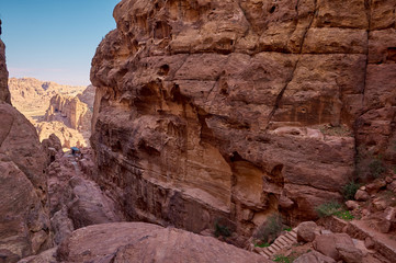 Ancient abandoned city in Petra mountains, Jordan. Old rock-cutted building at the background. Stairway leads to the top.