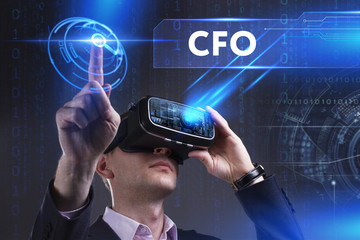 Business, Technology, Internet and network concept. Young businessman working in virtual reality glasses sees the inscription: CFO