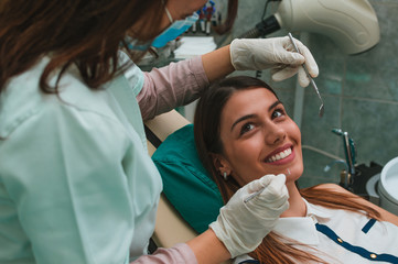 Woman at the dentist's chair during a dental procedure. Beautiful Female Smile