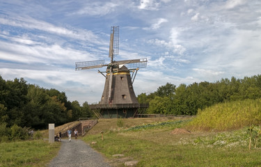 Beautiful old windmill against a blue sky and forest