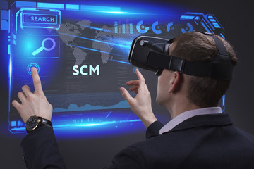 Business, Technology, Internet and network concept. Young businessman working on a virtual screen of the future and sees the inscription: SCM