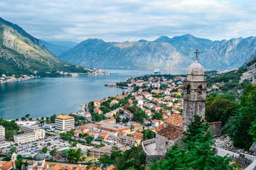 Panoramic view of town and mountains with church in foreground in Kotor, Montenegro