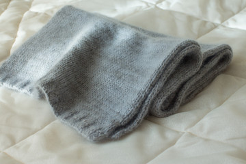 soft blue angora scarf tied by hand on natural wooden background with cotton branch