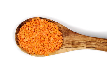 pile red lentils in wooden spoon isolated on white, top view