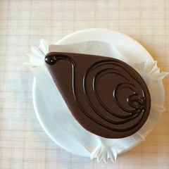 Chocolate Cake With Ganache Glaze decorate with chocolate hot fudge sauce with blur background tablecloth, tea time, closed-up, top view