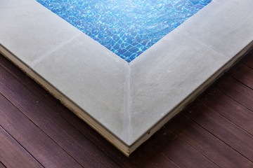 wooden terrace and border of swimming pool in daylight time with free copyspace for your creativity ideas text