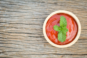 tomato sauce in a bowl and fresh tomatoes on old wood