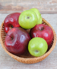 colored Apples from garden in a basket on a table