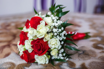 bouquet of red and white roses with wedding rings