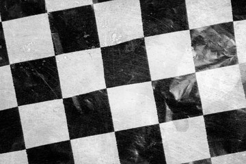 crumpled and scratched surface of cellophane with black and white squares.