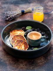 Cottage cheese pancakes syrniki with berries and honey