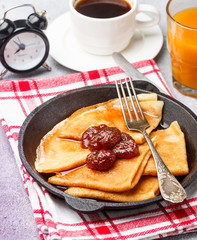Breakfast. Crepes. Thin pancakes with strawberry jam. Selective focus