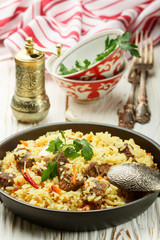 Pilaf with beef, carrots, onions, garlic, pepper and cumin. A traditional dish of Asian cuisine. Selective focus