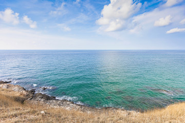 Fototapeta premium Beautiful seascape with rocks and meadow in cloudy blue sky