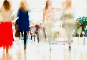 Abstract defocused motion blurred people, walking girlfriends in the shopping center, urban...