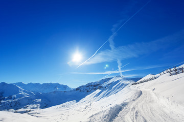 Snowcapped alpine path with anti avalanche barrier