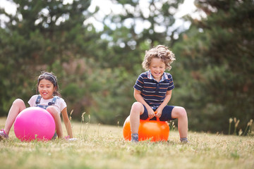 Junge und Mädchen auf einem Hüpfball