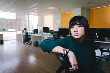 Young beautiful business woman with a sad expression on his face. She is very tired and waiting for the end of the day. Office life