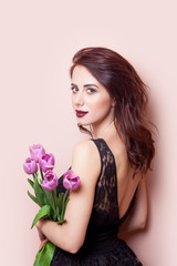 beautiful young woman with bunch of tulips on the wonderful pink background