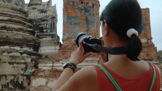 Woman is shooting a video of the three Chedis of Wat Phra Si Sanphet.
