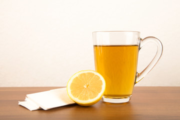 Tee mit Zitrone und Taschentücher während einer Krankheit