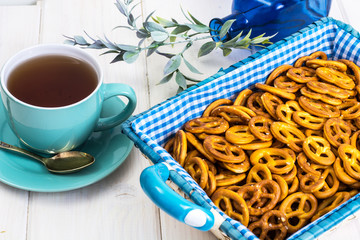 Small salted pretzels cookies in a basket on a white wooden tabl