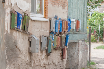 old mailboxes hanging on the outside wall under the window in the yard