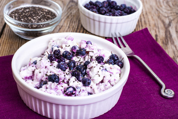 Cottage cheese with berries and chia seeds in white bowl
