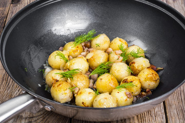 Fried potato dumplings with bacon in frying pan