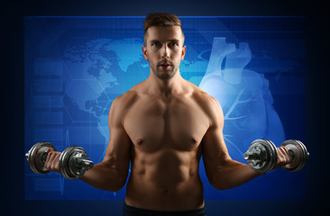 Fototapeta na wymiar Heart rate monitor concept. Young man training with dumbbells on blue background