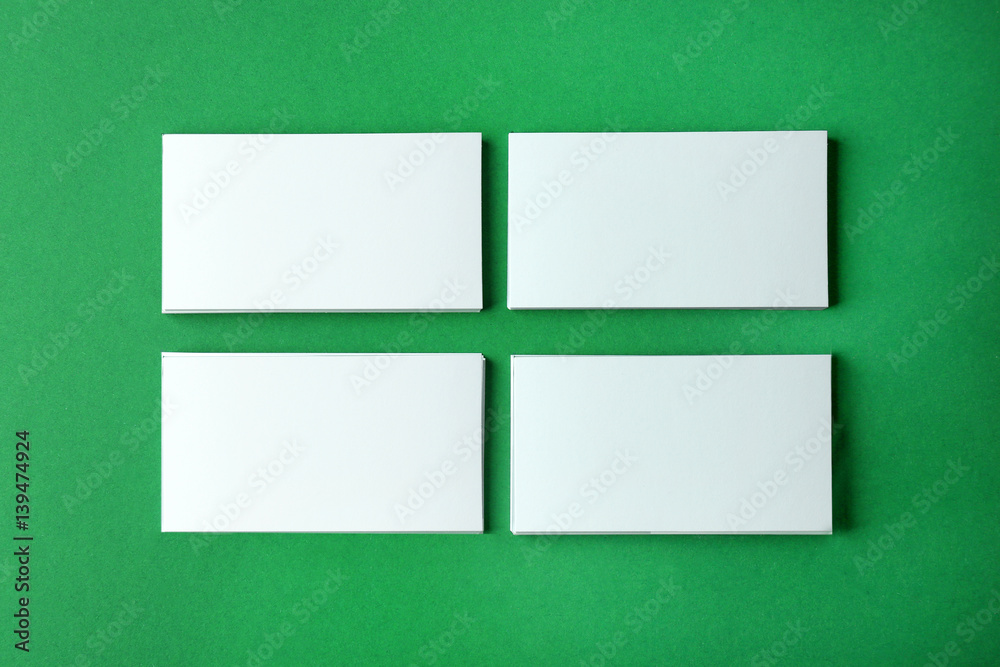 Wall mural blank business cards on green background