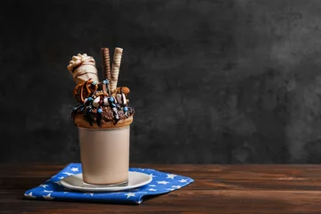Tuinposter Milkshake, donut and other sweets in glass on wooden table © Africa Studio