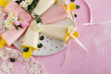 Homemade Ice cream yoghurt and flowers on a pink background