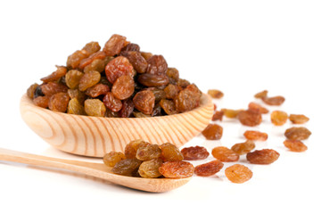 raisins in a wooden bowl with spoon isolated on white background