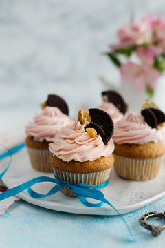 Pink cupcakes, decorated cookies, on a light background (close-up)