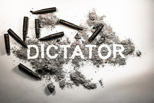 Dictator word written in  ash, dirt, dust with bullets around as dictatorship, power, war, revolution, tyranny, bad government or political system concept lent background